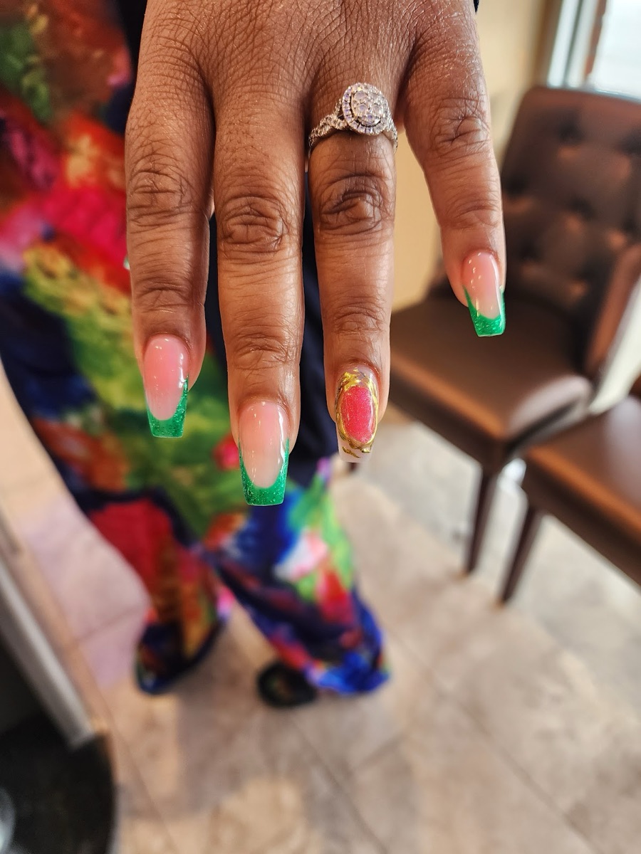 Green French-tip nails with a gold accent at the US Nails salon